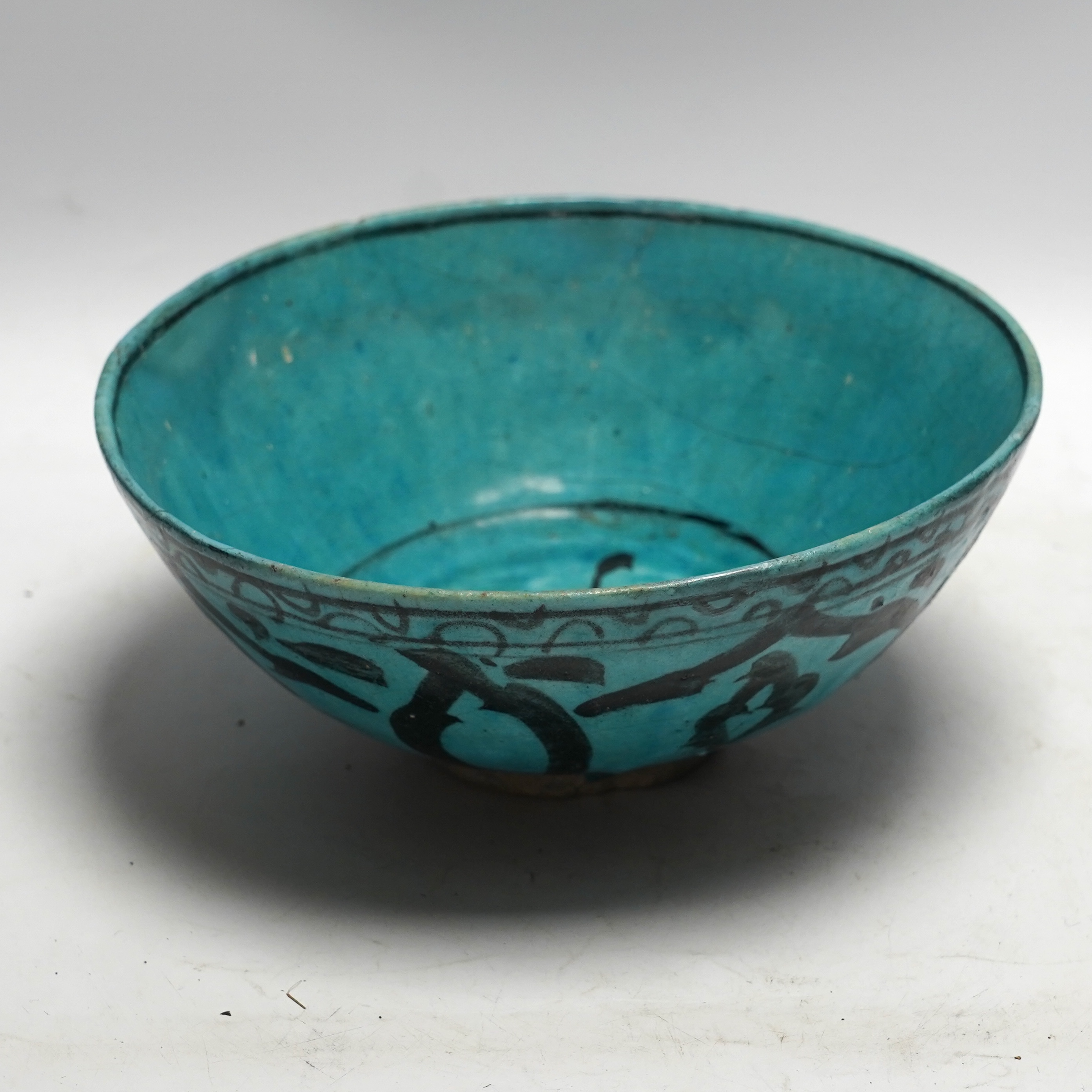 A Kashan turquoise glazed fritware bowl, Persia, 13th/14th century, 25cm diameter